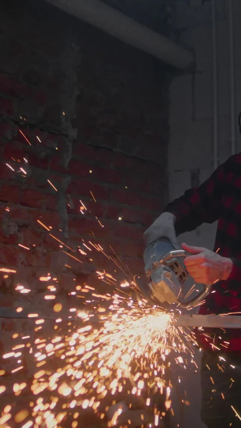 Man industrial worker or construction worker cuts metal with a angle grinder Stock Footage 348252077