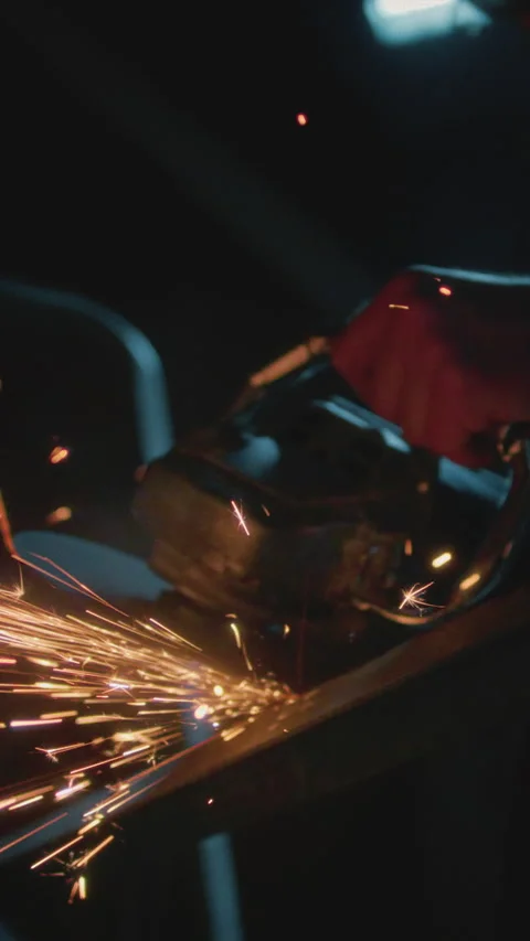 Man industrial worker or construction worker cuts metal with a angle grinder Stock Footage 348252577