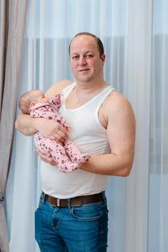 Man with infant posing at home. Authentic parenting lifestyle image suitable for Foto stock