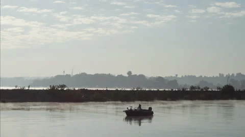 Man on an inflatable boat sits and throws a spinning or fishing rod into the Stock Footage 150278034