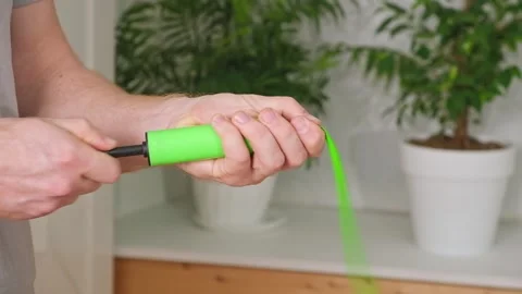 Man inflates a balloon with a pump. Blowing green balloon by hand air pump Stock Footage 242298787
