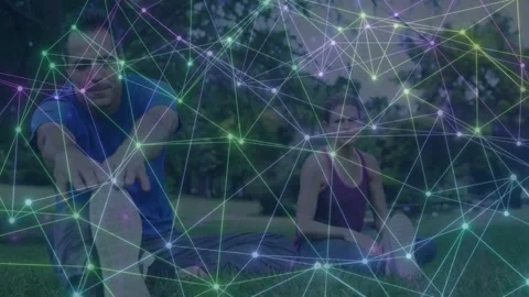 Man initiating deeper reach, pair doing leg stretch on grass, network overlay Stock Footage 333704587