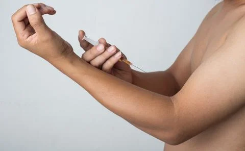 Man Injected into the arm Stock Photos
