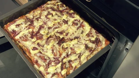 Man inserting a baking sheet of pizza into the oven, close-up Stock Footage 163859099