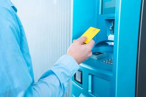 A man is inserting a blue plastic card into the machine Stock Photos