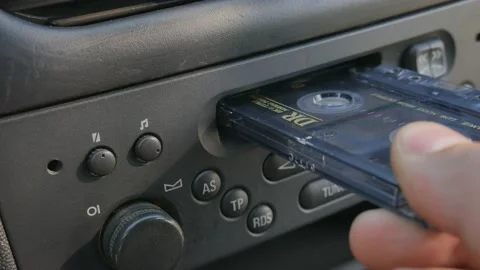 Man inserting the cassette into the old car cassette player. Stock Footage 113693438