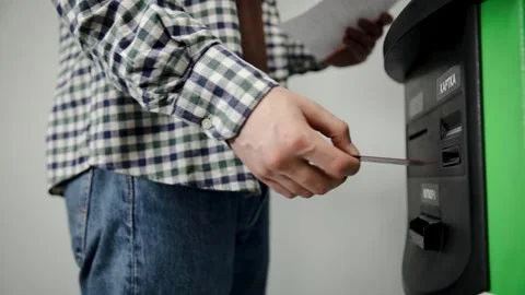 Man inserting credit card into atm machine for a secure cash withdrawal Stock Footage 333705829