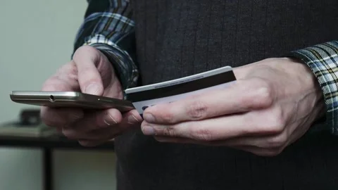 Man inserting credit card number on mobile phone. Online banking with smartphone Stock Footage 101898232