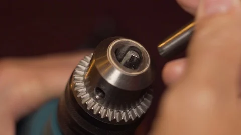 Man inserting a drill bit in an electric drill, close-up shot. Stock Footage 100107478