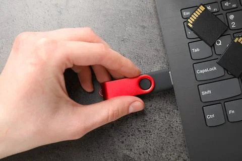 Man inserting modern flash drive at grey table, top view Stock Photos