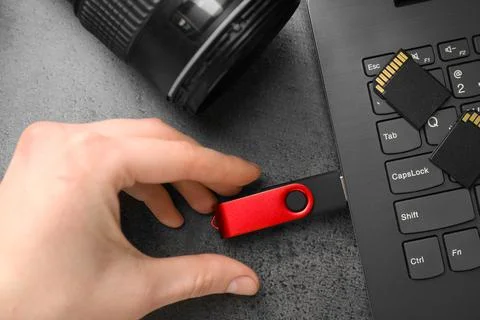 Man inserting modern flash drive at grey table, top view Foto stock