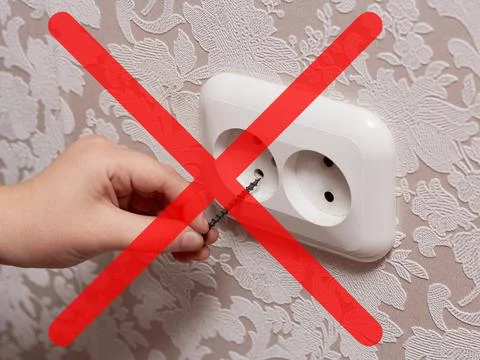 Man inserting a nail into an electrical outlet is dangerous, it is life-threa Stock Photos