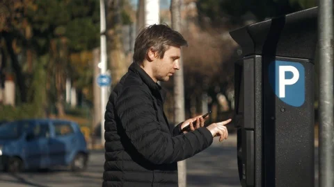 Man inserting a parking lot ticket at an automated pay machine pay with card Stock Footage 124204736