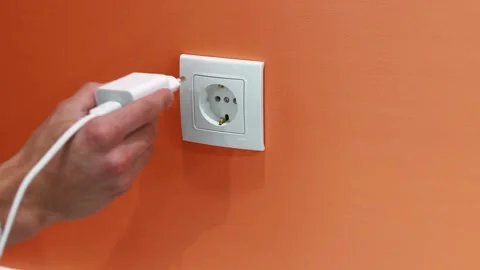 Man inserting Phone Charger into Wall Socket Stock Footage 258620959