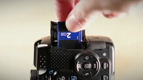 A Man Inserting an SD Card into a Digital Camera - 4K Stock Footage 171261753