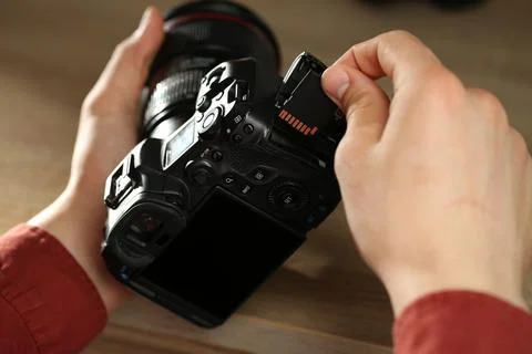 Man inserting SD memory card into photo camera at table, closeup Foto stock