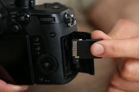 Man inserting SD memory card into photo camera, closeup Stock Photos