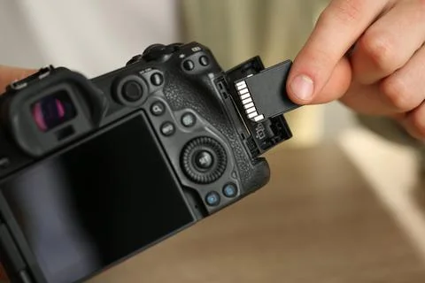 Man inserting SD memory card into photo camera, closeup Stock Photos