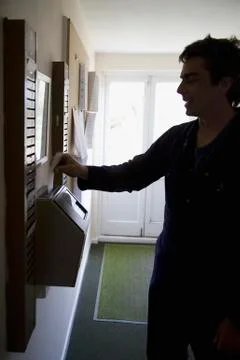 A man inserting a time card into a time clock Stock Photos