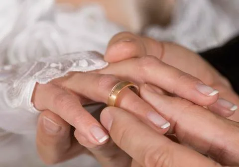 Man inserting wedding ring to wife, close up Stock Photos