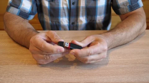 A man inserts and removes the cap of a USB flash drive, creating a distinctiv 動画素材 341254875
