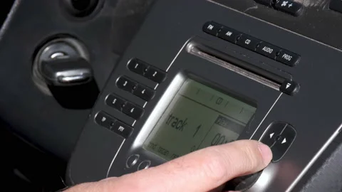 Man inserts an audio CD into the car stereo increases the volume using knob Stock-Footage 170394838
