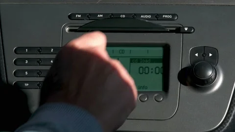 Man inserts an audio CD into the car stereo increases the volume using knob Video stock 170398005