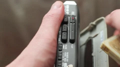 The man inserts a cassette into the old player and presses play. Stock Footage 60703723