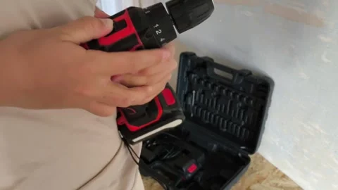 A man inserts a drill into a power drill. Tool attachments. Repair Stock Footage 322894341