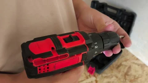 A man inserts a drill into a power drill. Tool attachments. Repair Stock Footage 322894451