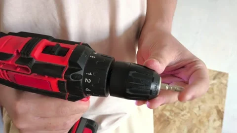 A man inserts a drill into a power drill. Tool attachments. Repair Stock Footage 322894464