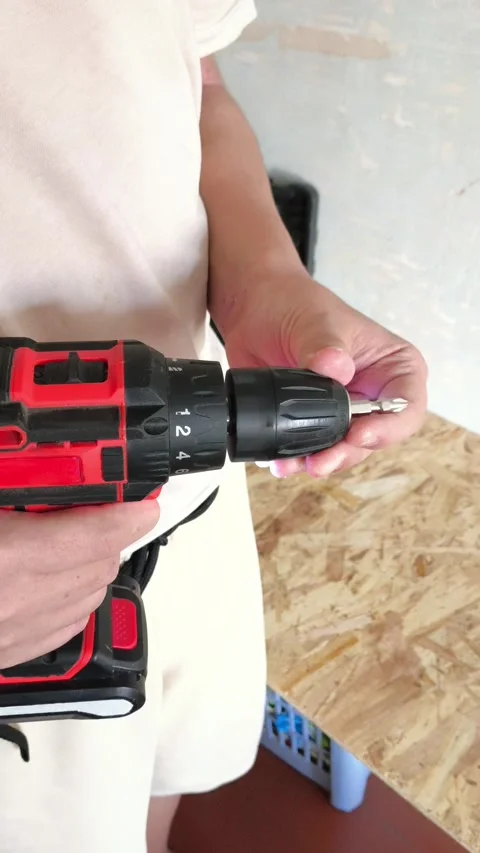 A man inserts a drill into a power drill. Tool attachments. Repair Stock Footage 322894528