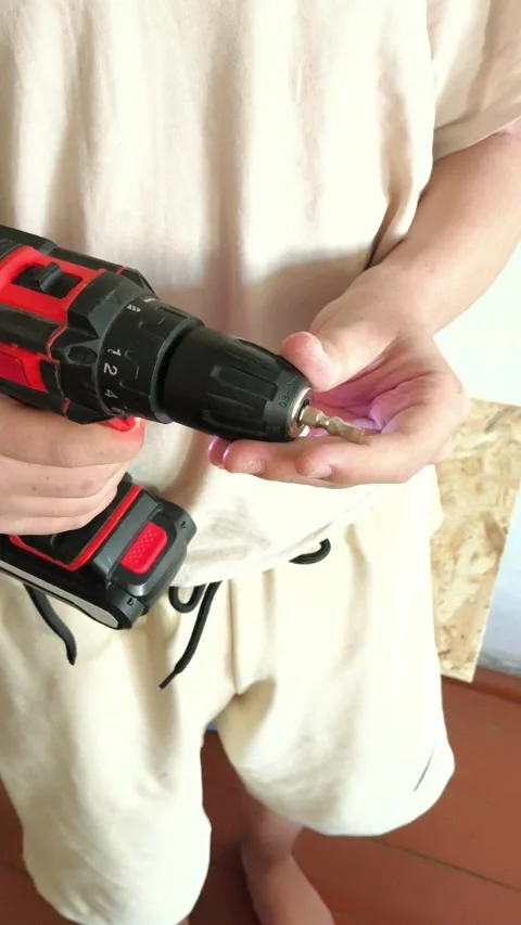 A man inserts a drill into a power drill. Tool attachments. Repair Stock Footage 322894584