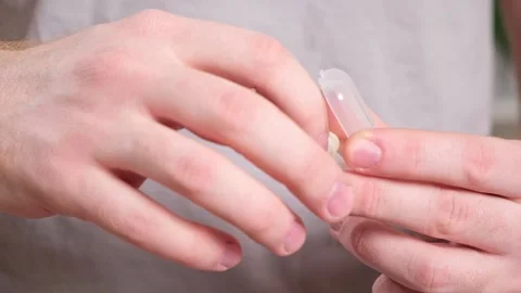 Man inserts earplugs so as not hear extraneous noise, music, snoring. Silicone Stock Footage 236920740