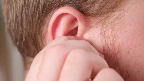 Man inserts earplugs so as not hear extraneous noise, music, snoring. Silicone Stock Footage 236921915