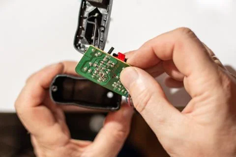 A man inserts an electronic board into Photos