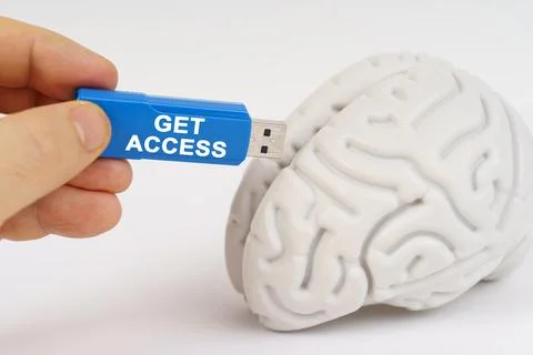 A man inserts a flash drive into his brain with the inscription - Get Access Stock Photos
