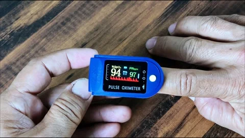 A man inserts his finger into a pulse oximeter to measure blood oxygen satu.. Stock Footage 295280439