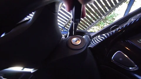 A man inserts a key from a rental car into the ignition switch and starts the Stock Footage 115702944