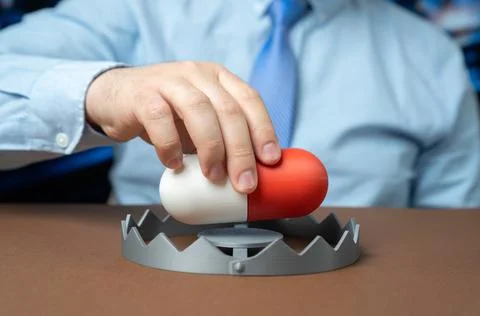 A man inserts a medication capsule into a trap. Drug addiction and medical .. Stock Photos
