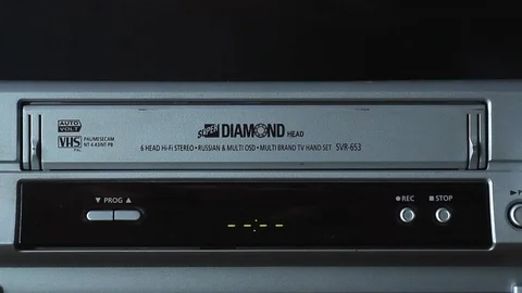 A man inserts an old video cassette into a player. Video stock 125513842