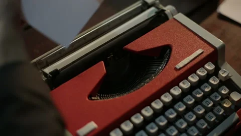 Man inserts paper into a vintage typewriter Stock Footage 86898287