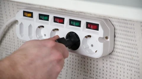 The man inserts the plug into adapter socket and presses the switch. Stock Footage 167929365