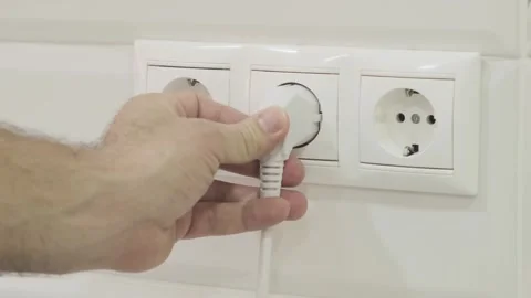 Man inserts  plug into an electrical outlet Stock-Footage 271070260