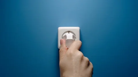Man Inserts Plug Into Electrical Socket On A Blue Wall Видео 110774607