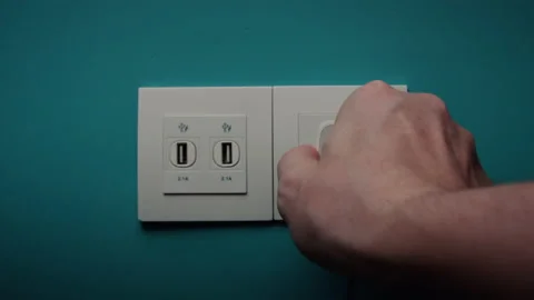 Man Inserts Plug Into Electrical Socket On A Blue Wall Stock Footage 197047082