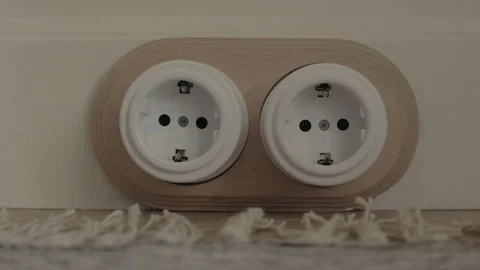 Man inserts plug into socket and then removes it in room Vídeo Stock 112267271