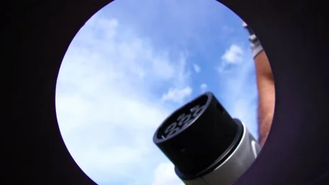 Man inserts a power cord into an electric car for charging Video stock 188511195