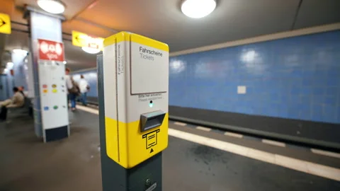 A man inserts a ticket into a machine in the Berlin underground, Germany. People Stock Footage 218486041