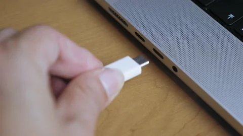 A man inserts a Type C cable into a laptop connector. Data transfer from phone Video stock 201826024